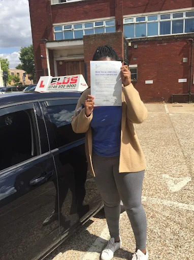Learner driver celebrating outside the test centre with their pass certificate