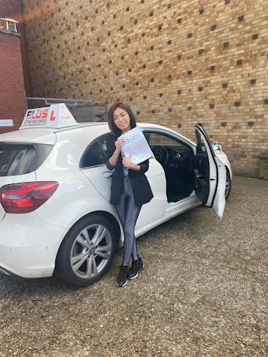 Excited student giving a thumbs up after passing their driving test first time